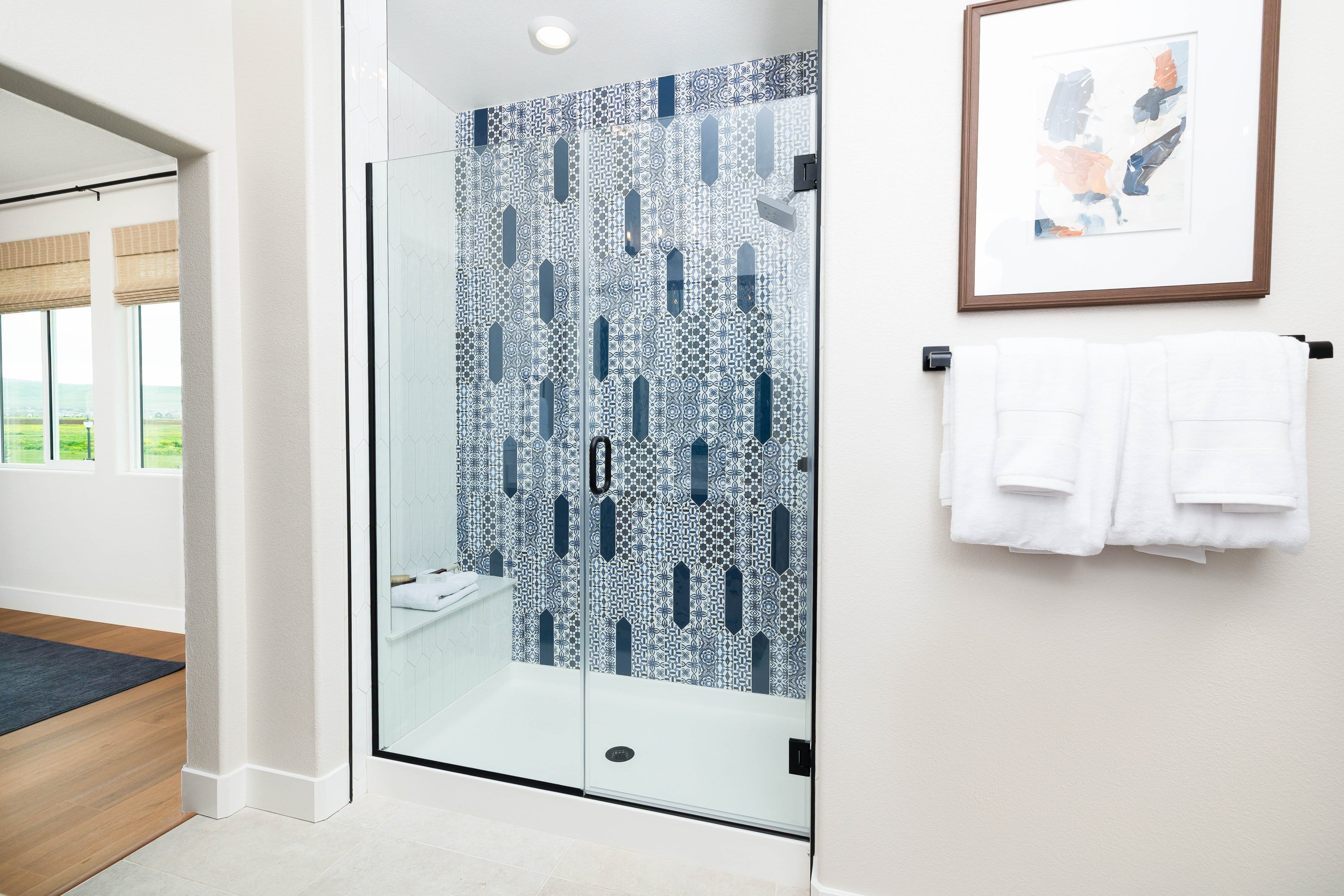 Full-length frameless shower door with matte black pull handle
