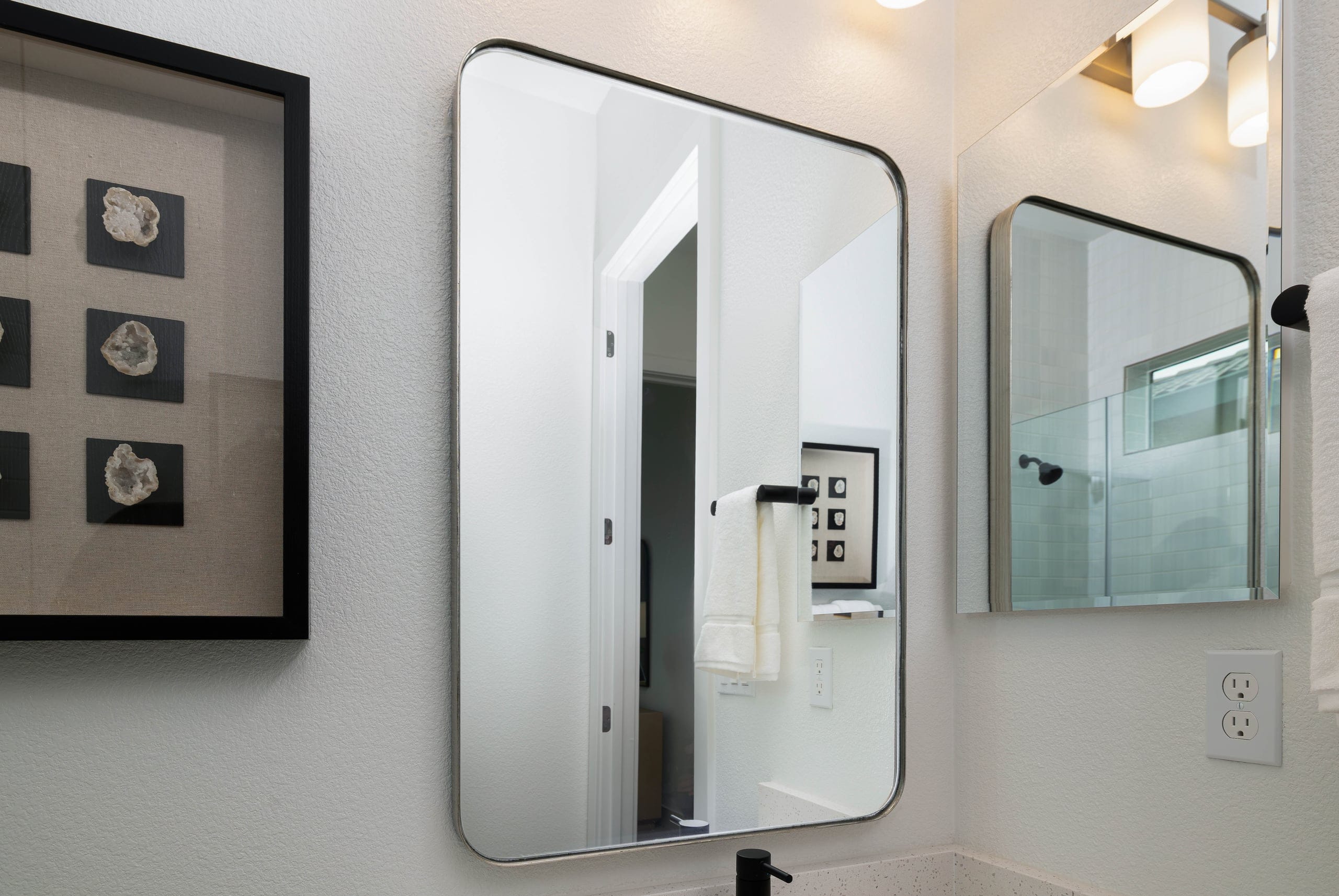 Round custom mirror installed above a residential bathroom vanity