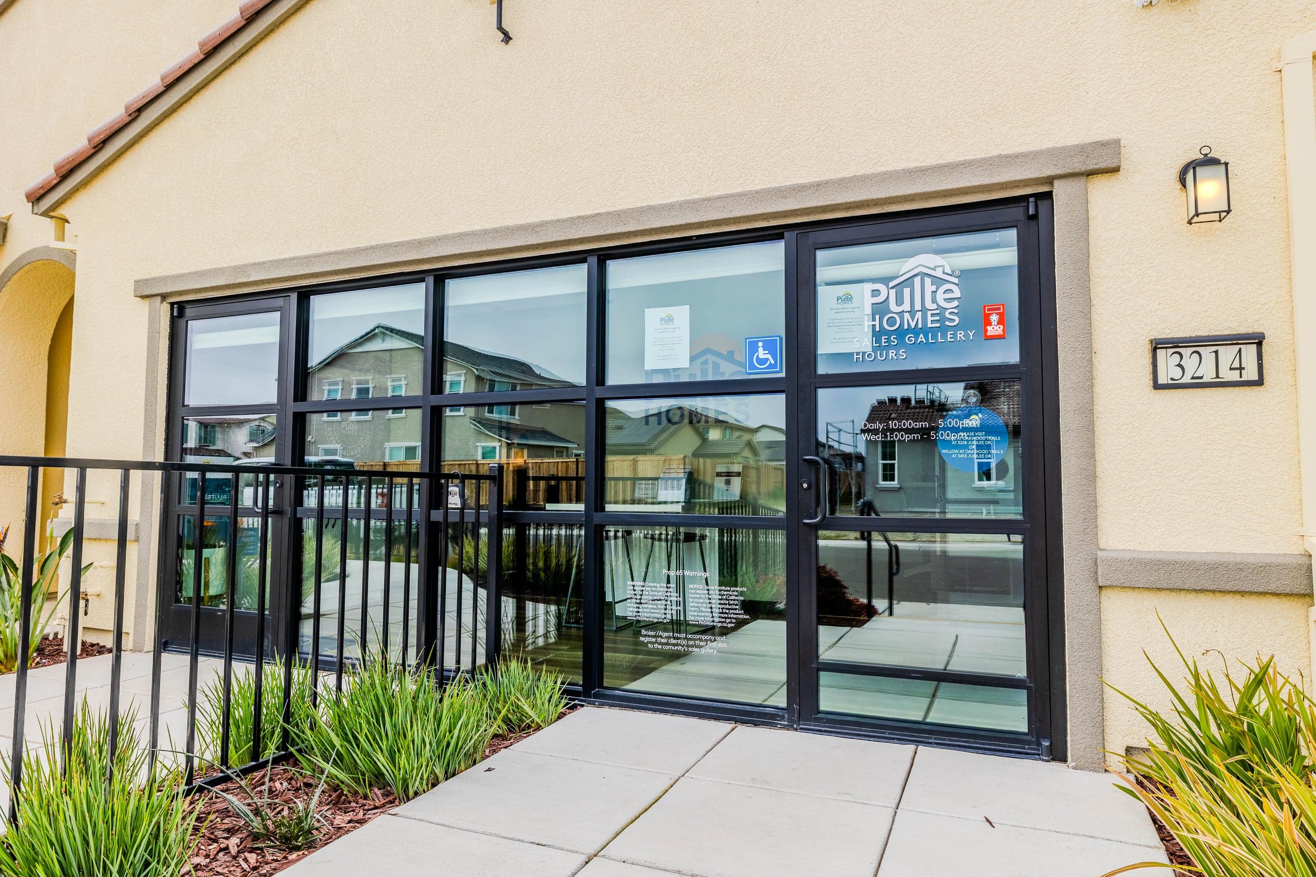 Black-framed glass office partitions with blue-tinted privacy glass forming individual suites in a DFW commercial buildout