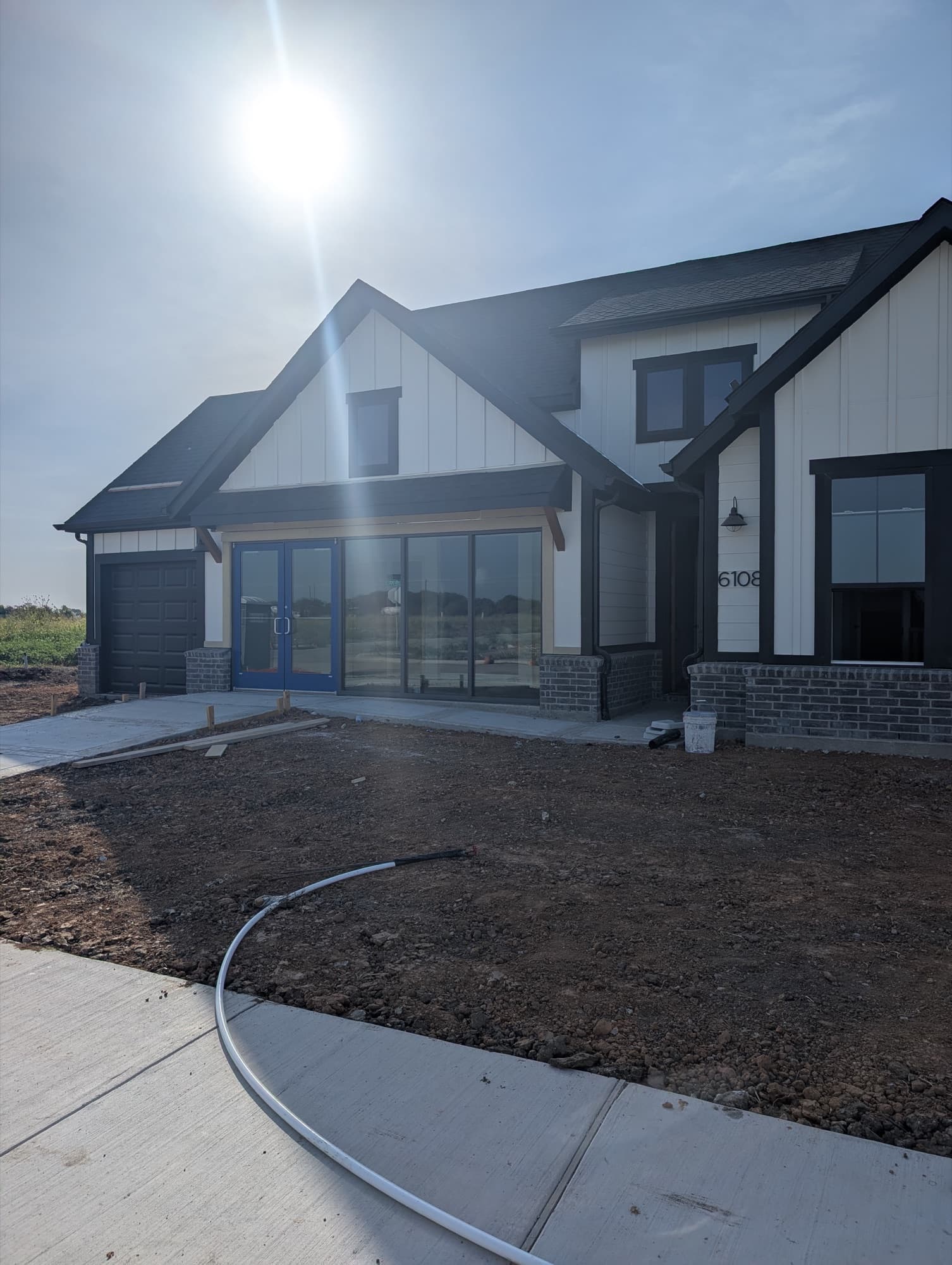 New-home builder’s sales office with blue-framed double glass doors, a storefront glass wall and insulated windows