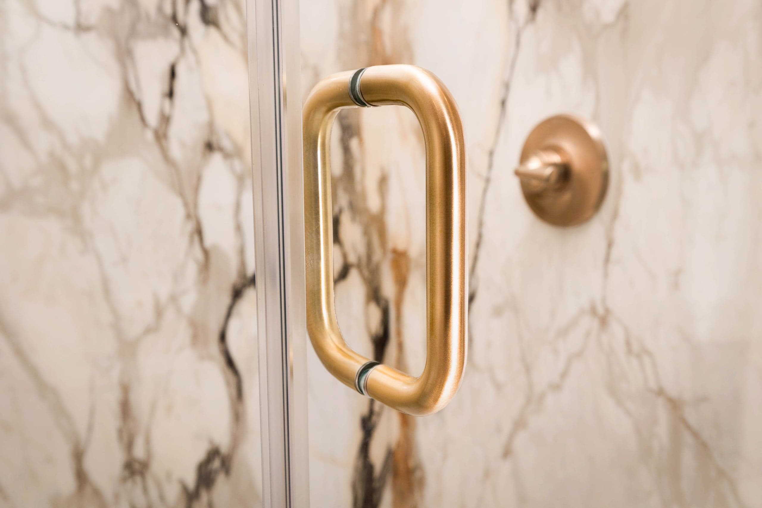 Frameless shower enclosure with brushed gold hardware and mitered corner in a Colleyville Vineyards primary bath