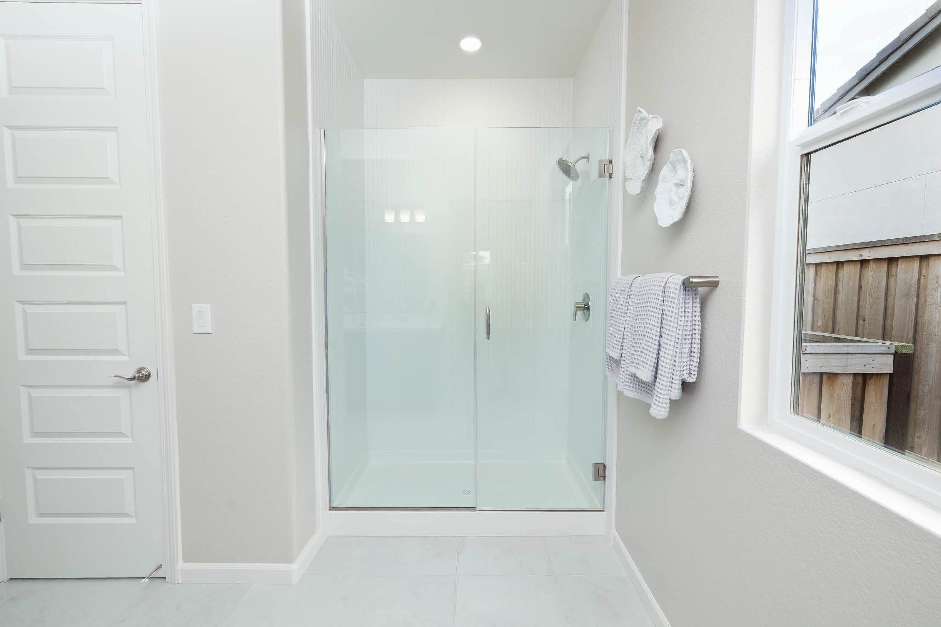 Semi-frameless shower with brushed metal hardware