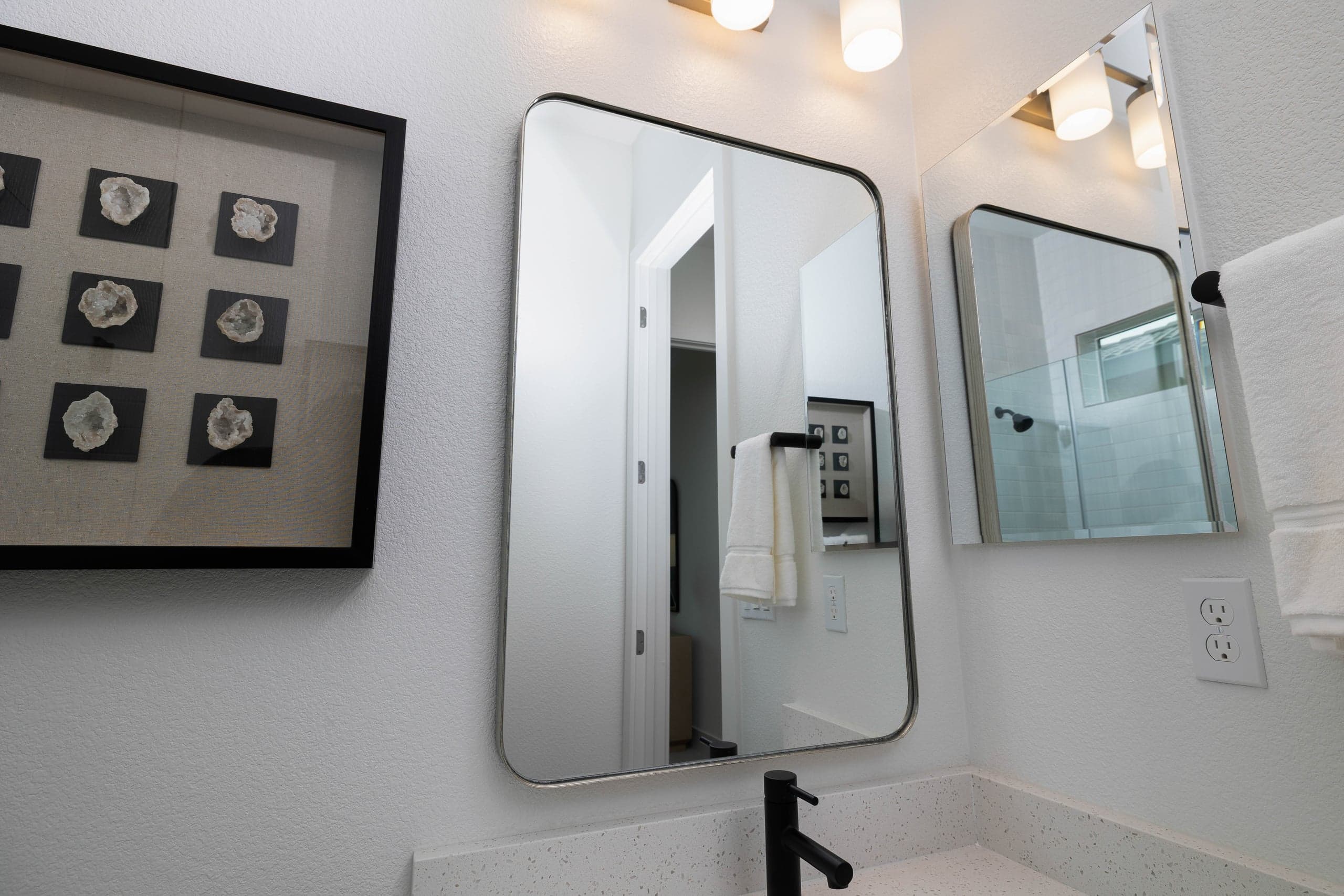 Custom arch-top decorative mirror with full-bevel edge in a McKinney Adriatica primary bathroom